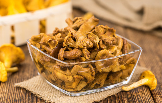 Portion of Preserved chanterelles on wooden background, selective focus