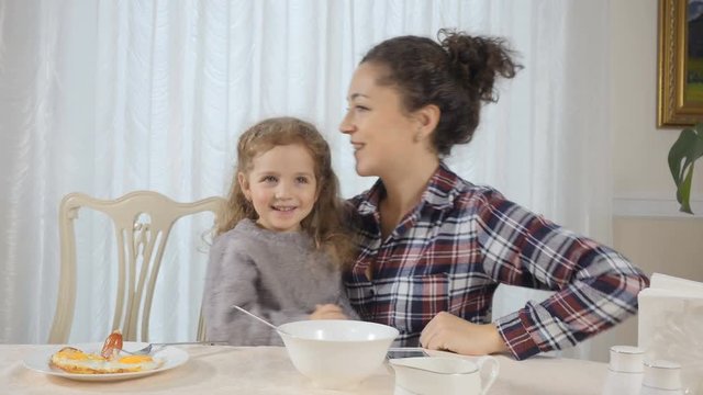 Woman and daughter have fun during breakfast