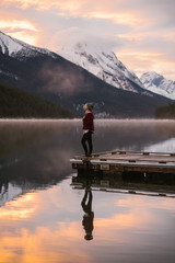 Young Woman on Misty Morning in the Mountains Standing on a Lake Dock - 178385977