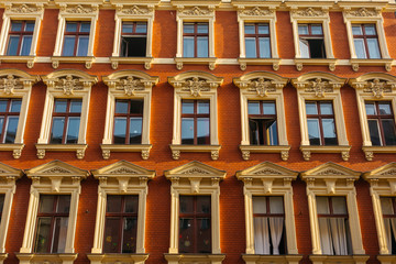 red facaded brick apartment building with stucco windows
