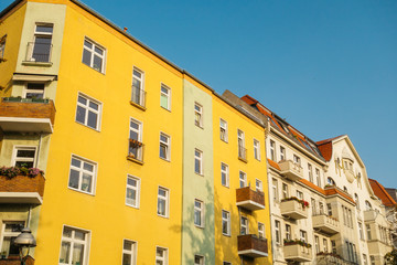 Fototapeta na wymiar colorful yellow house next to an white facaded apartment building