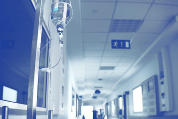 Intravenous system in the hospital hallway with blurred person afar