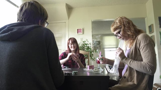 Medium shot of three women passing around a bong