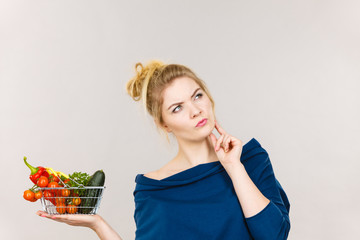 Woman with vegetables, thinking face expression