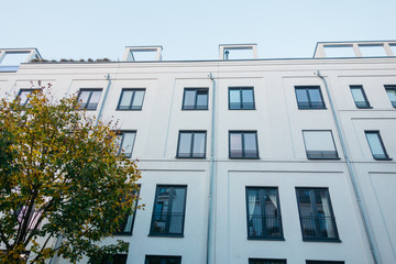 low angle view of white apartment building with green tree