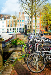 Row of bicycles standing next to canal in Amsterdam at spring, Netherlands, retro toned