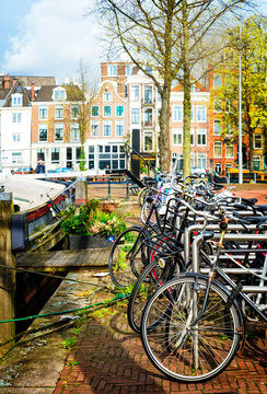 Row of bicycles standing next to canal in Amsterdam at spring, Netherlands, retro toned © neirfy