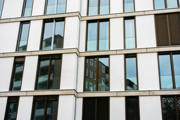 very modern white facade with glass reflections in the windows