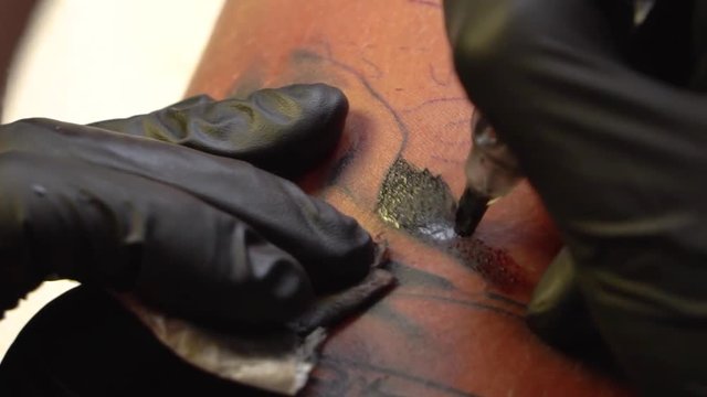 Tattoo applying ink on skin with tattoo machine