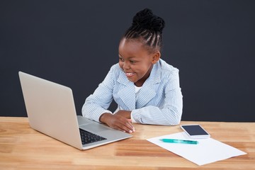 Happy businesswoman looking at laptop