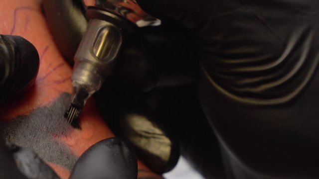 Tattoo machine applying ink on skin
