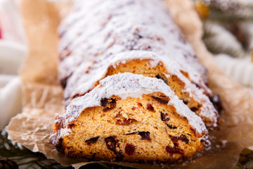 Dresdner Stollen is a Traditional German Cake with raisins on a light knitted background.Gift for Christmas.Vintage style.Fruit cake for the Holiday.