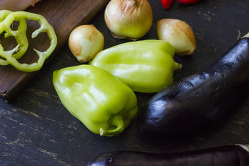 A composition of fresh vegetables laying on a dark wooden background