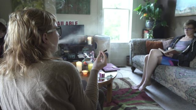 Medium wide shot of three women passing around a joint