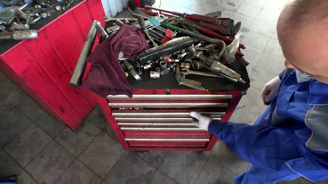 High angle view of male mechanic arranging tools in drawer