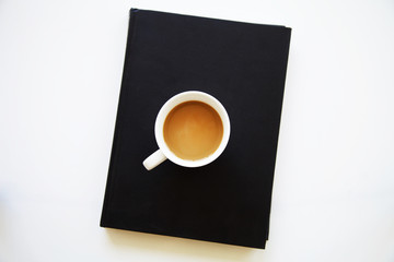 Coffee cup on black book
