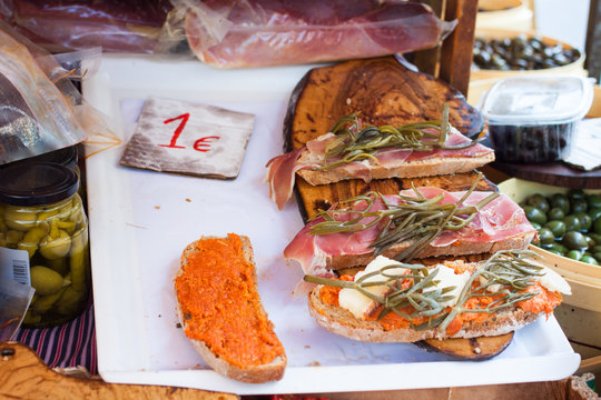 Bred with olive oil (pa amb oli) with jamon, sobrasada and Majorcan herbs for sale at Sineu market, Majorca, Spain
