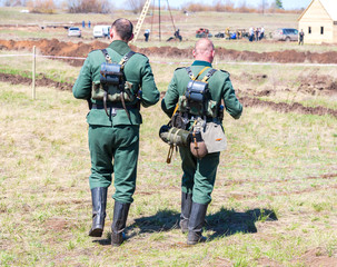 Unidentified members of Historical reenactment in German Army uniform during historical reenactment of battlefield in 1943 in summer day