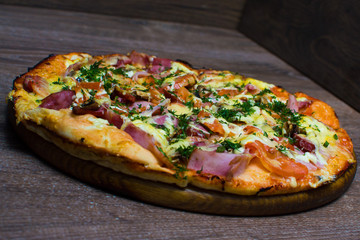 pizza with ham and cheese on a board