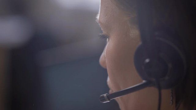 Crop shot of woman using headphones working as support center assistant