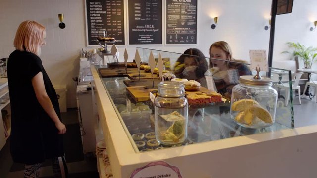 Medium shot of two women in a pastry shop