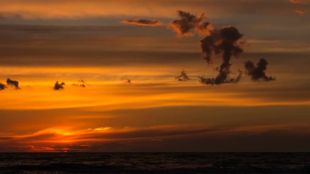 Beautiful golden sunset on the sea with unusual clouds. Time lapse.