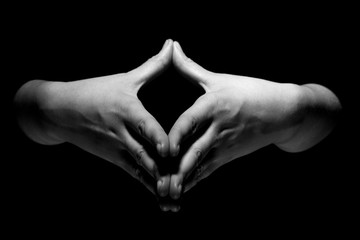 hands in mudra gesture on black background