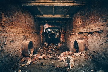 Old dark creepy underground brick tunnel or corridor or sewer pipeline at abandoned ruined...