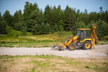 Obraz premium Wheel loader Excavator unloading sand with water during earth moving works at construction site