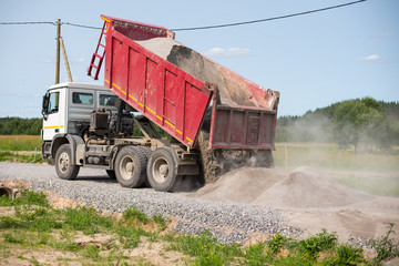 Dump truck is unloading soil. Dumper truck is unloading soil or sand at construction site