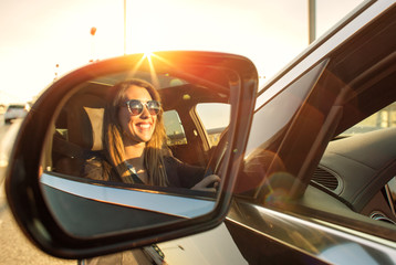 Beautiful businesswoman in rear view mirror with sunglasses