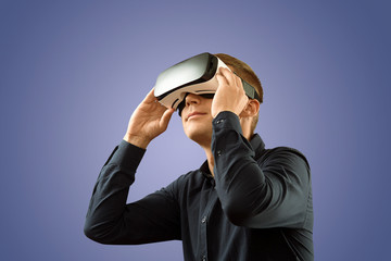 Fototapeta premium Smartphone using with VR glasses. Man wearing virtual reality glasses. Virtual reality today.