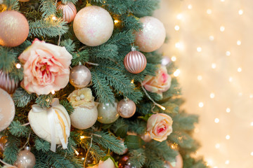 Fototapeta na wymiar Beautiful christmas tree decorated with flowers, balls and girland, close-up. New year decoration.