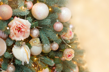 Beautiful christmas tree decorated with flowers, balls and girland, close-up. New year decoration.