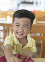 toothy smiling face happiness emotion of asian children sitting on food table