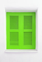 Green wooden window on white cement wall.