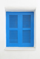 Blue wooden window on white cement wall.