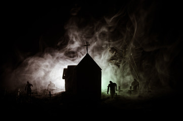 Scary view of zombies at cemetery dead tree, moon, church and spooky cloudy sky with fog, Horror Halloween concept