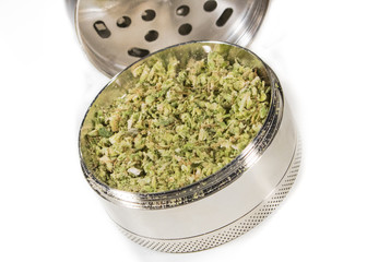 marijuana herb in stainless steel grinder isolated on white background