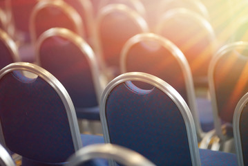 Rows of empty metal chairs in a large assembly hall.Empty chairs in conference hall.Interior...