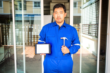 technician in blue suit hond hammber and tablet