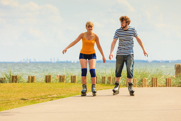 Young couple on roller skates riding outdoors