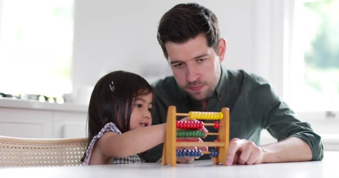 Girl using abacus to count with Father