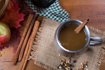 Cup with apple cider and rustic fall decor top view