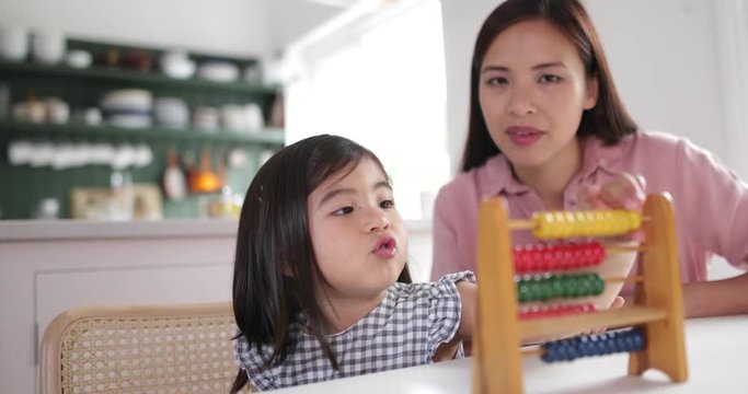 Girl using abacus to count with Mother