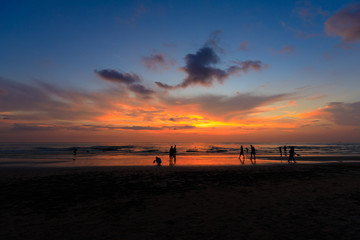 Silhouette people at the sunset beach with orange sky with beautiful blue, evening time.