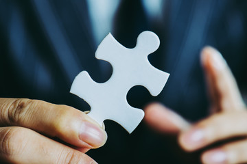 パズルのピースを持っているビジネスマン