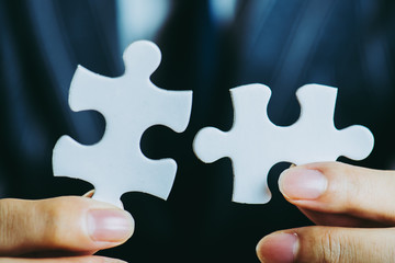 パズルのピースを持っているビジネスマン