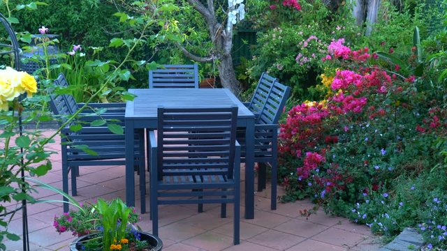 Beautiful springtime Mediterranean style courtyard garden, entertaining area close up, handheld panning.