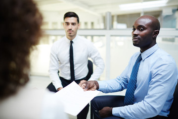 Human resourses manager showing contract to one of candidates for new vacancy